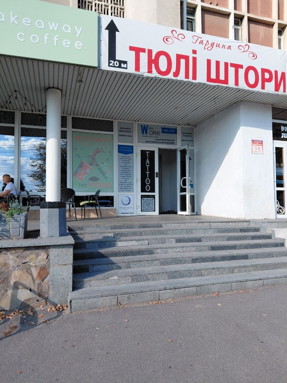 Вхід у будівлю: сходи біля кав’ярні та вивіски